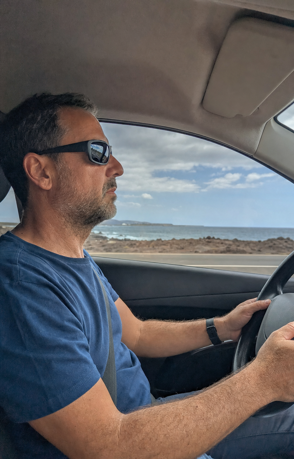 Conductor con gafas polarizadas en una carretera costera de Canarias